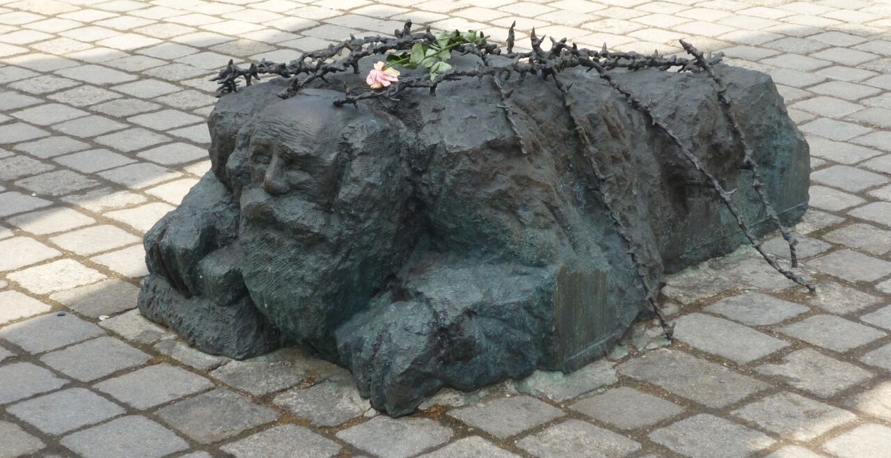 Kniender_Strassenwaschender_Jude_Wien - © Wikimedia   -- Skulptur des straßenwaschenden Juden im "Mahnmal gegen Krieg und Faschismus", Wien, von Alfred Hrdlicka