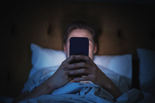 Handy, Surfen, Bett, Nachts, Zocken, Mobile Phone, Smartphone - Das Foto zeigt einen jungen Burschen, der im Bett liegt und in sein Smartphone starrt.&nbsp; - © Foto: iStock/gorodenkoff