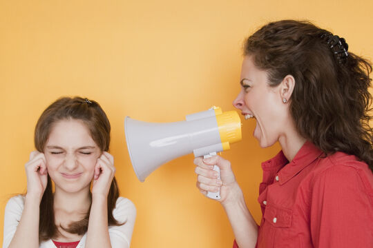 Konflikt Eltern Kinder Matura - Eine Mutter mit einem Megaphon ruft ihrer Tochter, die sich die Augen zuhält, ins Ohr.&nbsp; - © Symbolfoto: iStock/ Jamie Grill