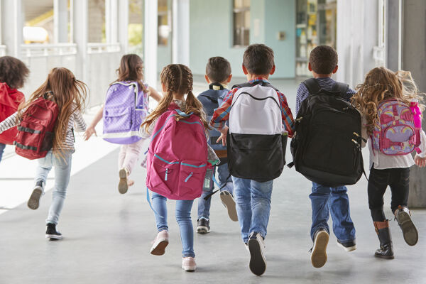 Kinder in einer Schule - Kinder mit Schultaschen laufen in einer Schule. - © Foto: iStock/monkeybusinessimages