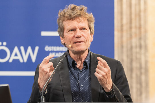 Hartmut Rosa bei der Karl-Popper-Lecture in Wien - Das Foto zeigt den Soziologen Hartmut Rosa bei einem Vortrag vor einem blauen Hintergrund mit dem ÖAW-Logo - © ÖAW Daniel Herramskogler