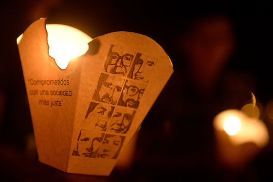 Märtyrer-Andenken - © Foto: APA / Marvin Recinos (Kerze bei Gedenkprozession, auf dem Windfang die Fotos der Ermordeten)
