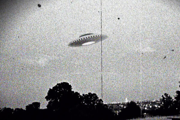 UFO paranormal Alien Außerirdische - Schwarz-weiße Aufnahme eines runden, scheibenförmigen Objekts mit Lichtpunkten am Rand, das über Bäumen schwebt. 1966 sorgte das „Westall-UFO“, ein unidentifiziertes Flugobjekt bei Melbourne, für Aufsehen (historische Aufnahme). - © oto: Getty Images / Universal Images Group / Universal History Archive