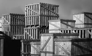 Kistenburg - Schwarz-weiß Foto, auf dem ein Stapel von großen Holzkisten zu sehen ist. - © Foto: iStock/italianestro