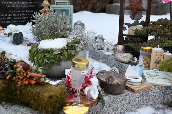 Grab für Sternenkinder am Friedhof Zams, Tirol - Das Foto zeigt ein Grab für Sternenkinder mit Kerzen und Dekorationen. - © Katharina Zangerl