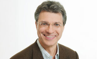 Yuri Kazepov, Stadtsoziologe der Universität Wien - Das Porträt zeit Yuri Kazepov in einem braunen Anzug vor weißem Hintergrund - © Barbara Mair