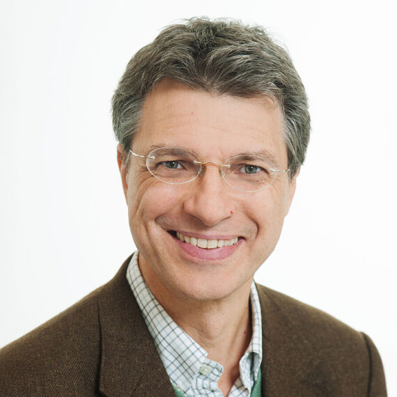 Yuri Kazepov, Stadtsoziologe der Universität Wien - Das Porträt zeit Yuri Kazepov in einem braunen Anzug vor weißem Hintergrund - © Barbara Mair