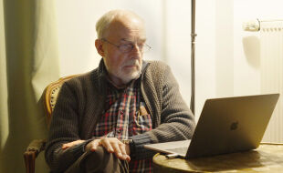 Johann F. Spittler - Das Porträt zeigt Doktor Friedrich Spittler vor seinem Laptop an einem Fenster.  - © "Grünes Licht" / Pavel Cuzuioc / Stadtkino Filmverleih