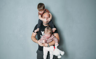 Vater mit Kindern - Das Foto zeigt einen überforderten Papa mit zwei kleinen Kindern - © Adobe Stock / Olga