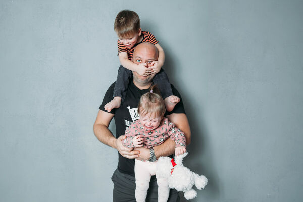 Vater mit Kindern - Das Foto zeigt einen überforderten Papa mit zwei kleinen Kindern - © Adobe Stock / Olga