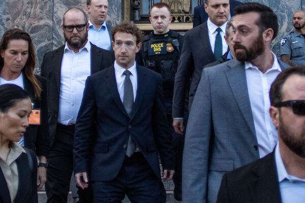 Meta Facebook Chef Mark Zuckerberg - Meta-Chef Mark Zuckerberg vor einem Gerichtsgebäude in Los Angeles. Er ist in der Mitte des Fotos zu sehen und geht gerade die Stiegen hinunter. Er hat lockige braune Haare. Er trägt einen schwarzen Anzug, weißes Hemd und graue Krawatte. Um ihn herum sind weitere Männer und Frauen in Anzügen zu sehen. Hinter ihm steht ein Polizist mit schwarzer Kleidung und einer schusssicheren Weste. Im Hintergrund ist die Außenfassade aus Marmor des Gerichtsgebäudes zu sehen. - © Foto: APA / AFP / Apu Gomes