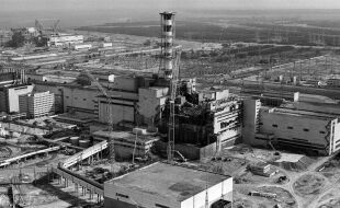 Tschernobyl Atomunfall Reaktorunfall - Schwarz-weiße Luftaufnahme des zerstörten Reaktorgebäudes von Tschernobyl mit umliegenden Industrieanlagen und Bauarbeiten - © Foto: APA / AFP / Vladimir Repik 