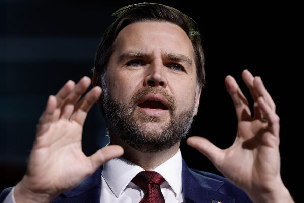 US-Vizepräsident JD Vance - Der US-amerikanische Vizepräsident JD Vance trägt einen dunklen Anzug und eine rote Krawatte. Er hebt seine beiden Hände und spreizt seine Finger und steht vor einem dunklen Hintergrund. - © APA / AFP / POOL / Chip Somodevilla 
