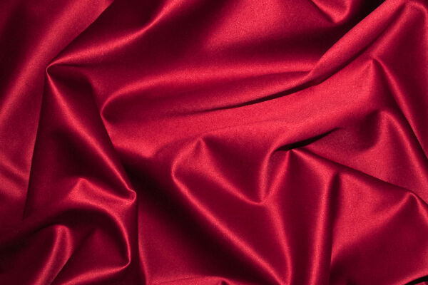 Satin Sex Erotik Knistern Rot - Glänzender, rot schimmernder Satinstoff mit weichen Falten - © Foto: Adobe Stock / Carola Vahldiek