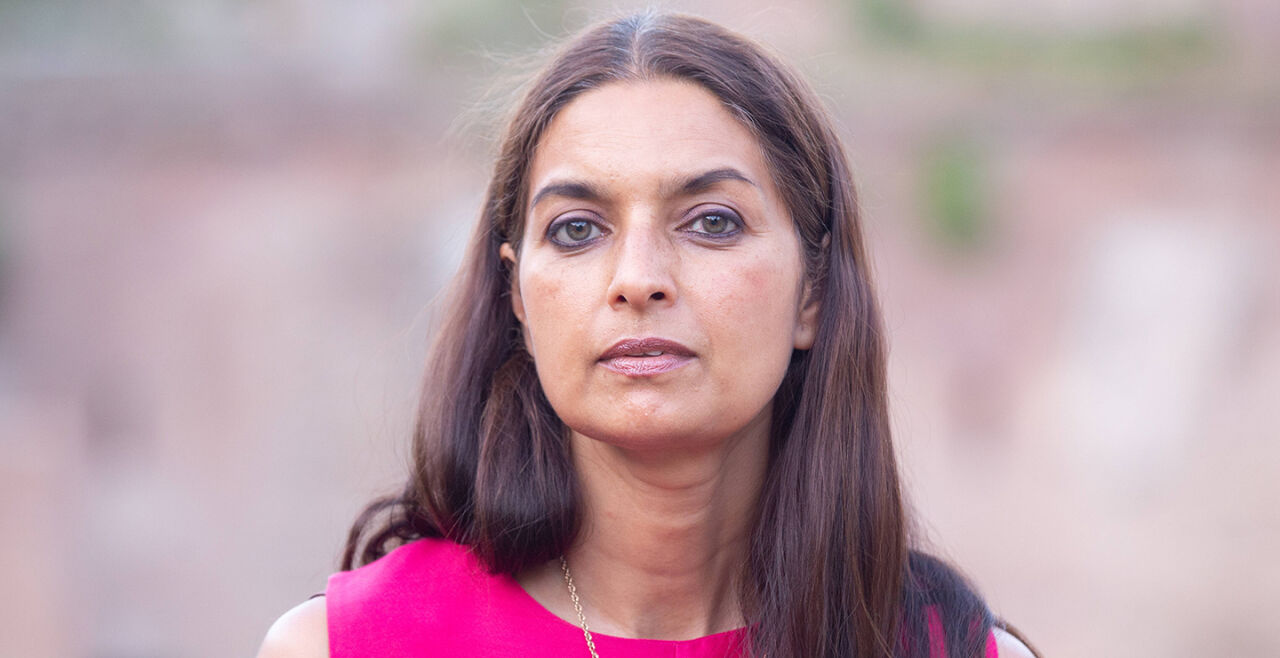 Jhumpa Lahiri - Jhumpa Lahiri mit langen, glatten Haaren trägt ein pinkfarbenes Oberteil und eine silberne Halskette vor unscharfem Hintergrund. - © Foto: IMAGO / Pacific Press Agency