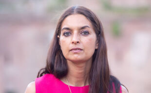 Jhumpa Lahiri - Jhumpa Lahiri mit langen, glatten Haaren trägt ein pinkfarbenes Oberteil und eine silberne Halskette vor unscharfem Hintergrund. - © Foto: IMAGO / Pacific Press Agency