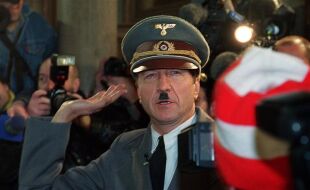 Er ist wieder da! - Opernballprotest im Jahr 2000 - Im Jahr 2000 schaffte es der Protest gegen die kurz davor angelobte schwarz-blaue Regierung bis in die Wiener Staatsoper. Der Kabarettist und Schauspieler Hubsi Kramar lässt sich als täuschend echter Adolf Hitler in einem weißen Rolls-Royce zum Opernball bringen. Er schafft es bis zur Feststiege, bevor ihn die Polizei festnimmt. - © APA-Images / Alexander Tuma