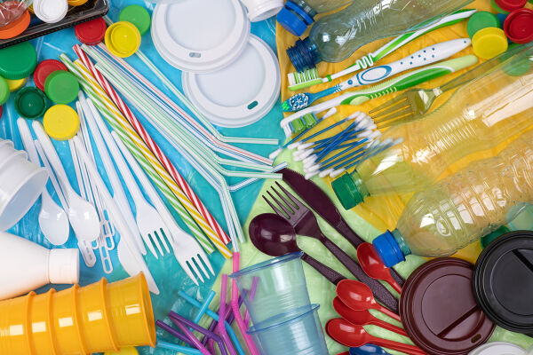 Plastik  - Verschiedene bunte Einweg-Plastikartikel wie Flaschen, Besteck, Strohhalme, Becher und Deckel liegen durcheinander auf einer Fläche - © Foto: Adobe Stock / photka