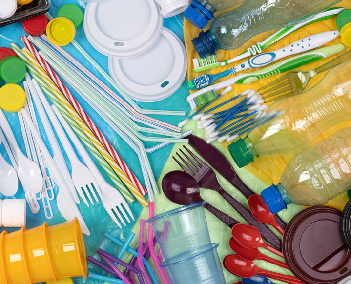 Plastik  - Verschiedene bunte Einweg-Plastikartikel wie Flaschen, Besteck, Strohhalme, Becher und Deckel liegen durcheinander auf einer Fläche - © Foto: Adobe Stock / photka