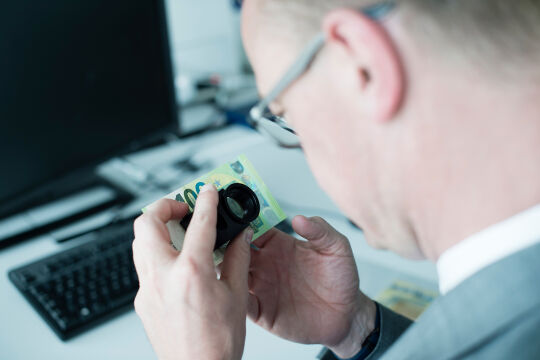 Detailarbeit - Harald Deinhammer kontrolliert die Sicherheitsmerkmale einer 100-Euro-Note nach der Devise "Fühlen, Sehen, Kippen".<br />
 