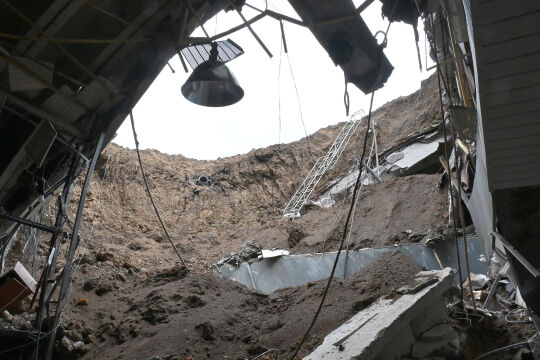 Bombenkrater - ©  APA / AFP / Sergey Bobok  -  Blick aus einem Unterstand auf einen Bombekrater in Charkiw, 17.4.2022